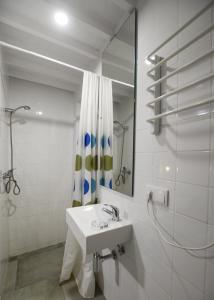 een witte badkamer met een wastafel en een spiegel bij Quinta do Paraizo in Ribeira Grande