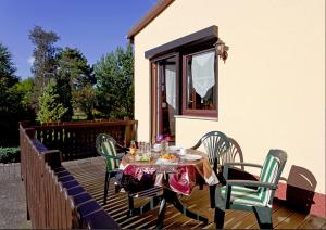 ein Tisch und Stühle auf einem Holzdeck in der Unterkunft Bungalow "Wiesenblick" in Trassenheide