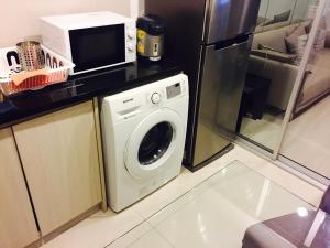 eine Küche mit einer Waschmaschine und einer Mikrowelle in der Unterkunft Luxury Apartment near Downtown (Pick-up Service) in Bangkok