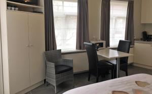 a room with a table and chairs and a kitchen at Guesthouse De Middelvelden in Arendonk