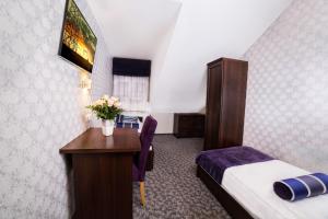 a hotel room with a bedroom with a desk and a bed at Dwór Olimp in Stalowa Wola +26 photos