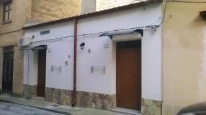a white building with two doors on a street at Casa Azzurra in Castellammare del Golfo