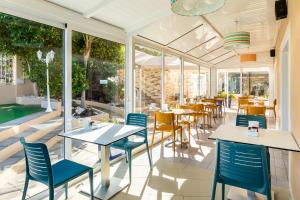 a restaurant with blue chairs and tables and windows at Apartamentos Los Dragos del Norte in Puerto de la Cruz