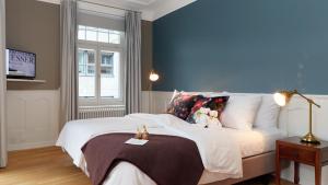 1 dormitorio con 1 cama grande y pared azul en Blue City Boutique Hotel, en Baden