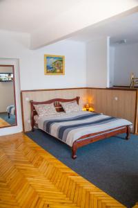 een slaapkamer met een groot bed met een houten hoofdeinde bij ART ApartmenT in Ternopilʼ
