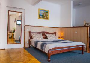 een slaapkamer met een groot bed en een spiegel bij ART ApartmenT in Ternopilʼ