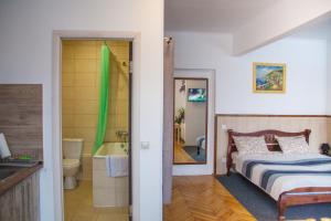 a bedroom with a bed and a bathroom with a tub at ART ApartmenT in Ternopilʼ