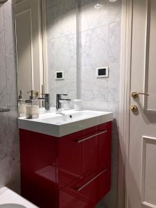 a bathroom with a red sink and a mirror at Appartamento Duomo in Florence