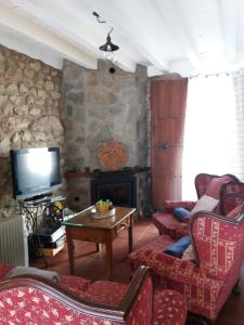 sala de estar con chimenea y TV en Casa Nani, en Benaocaz
