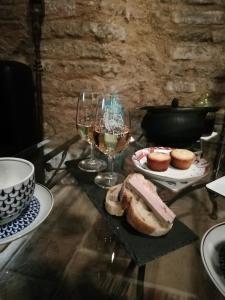 einen Tisch mit Gläsern Wein und einem Teller Brot in der Unterkunft La lauze et l'anguille in Gaillac