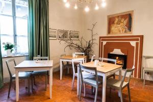 a dining room with tables and chairs and a fireplace at Ca'diFra in Casalborgone