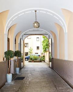 a hallway with an archway with potted plants at Brunnenhof City Center in Munich