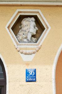 Una statua di una donna sul lato di un edificio di Brunnenhof City Center a Monaco