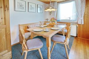 - une salle à manger avec une table et des chaises en bois dans l'établissement Bergblick, à Fischen im Allgäu
