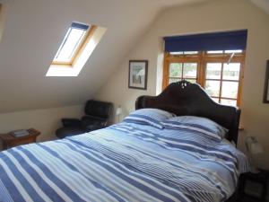 ein Bett mit einer blau-weißen gestreiften Bettdecke in einem Schlafzimmer in der Unterkunft Sail Loft in Eastbourne