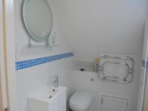 a bathroom with a white toilet and a mirror at Sail Loft in Eastbourne