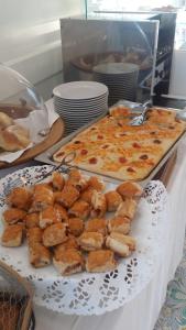 a table with a plate of food and a pizza at Relais Maresca Luxury Small Hotel & Terrace Restaurant in Capri