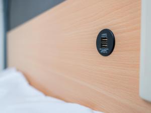 a black remote control on the side of a bed at Super Hotel Tokyo Kameido in Tokyo