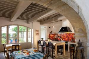 a kitchen with a table and chairs in a room at La Maison Sur La Sorgue - Esprit de France in L'Isle-sur-la-Sorgue