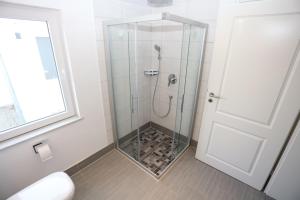 a bathroom with a shower with a glass door at Hafenkieker in Greetsiel +18 photos