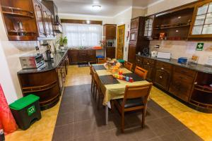eine Küche mit einem Tisch, Stühlen und einer Theke in der Unterkunft Casa Barão das Laranjeiras in Ponta Delgada