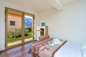 ein Schlafzimmer mit einem Bett und einem großen Fenster in der Unterkunft Apartment Castellino in Kotor