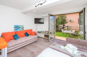 ein Wohnzimmer mit einem Sofa und einem TV in der Unterkunft Apartment Castellino in Kotor