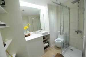 a bathroom with a shower and a sink and a toilet at Duas Torres - Appartment in Funchal