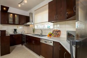 een grote keuken met houten kasten en een spoelbak bij Sea Side House Rapanas in Falasarna +20 foto's