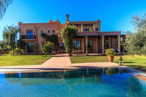 a large house with a swimming pool in front of it at Villa 69 Samanah Golf Country Club in Ala el Ma