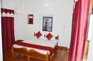 a bedroom with a bed with red curtains at Gajanand Guest House in Jaisalmer