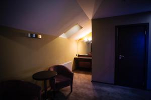 a dark room with a door and a table and chairs at LH Hotel&SPA in Lviv