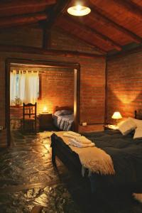 1 dormitorio con 2 camas y pared de ladrillo en Criollo Lodge en El Hoyo