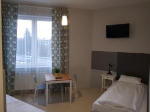 1 dormitorio con cama, mesa y ventana en Noclegi MaxTrans en Mielec
