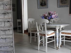 a dining room table with chairs and a vase of flowers at Le logis d'Antoine in Orléans