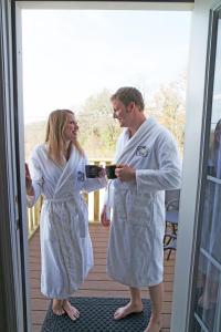 a man and woman in white robes standing on a porch at The Inn at Deer Creek Winery in Shippenville