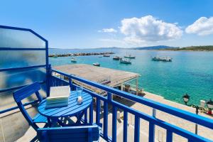 ein blauer Stuhl auf einem Balkon mit Blick auf einen Wasserkörper in der Unterkunft Angeliki Seaside Hotel in Aliki