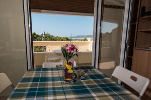 a table with a vase of flowers on it at Casa Cicale in Porto Heli