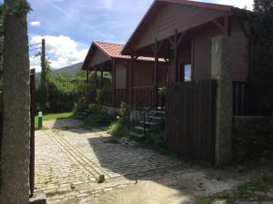ein kleines Haus mit einem Tor davor in der Unterkunft Casitas Cinco Castaños in Candelario