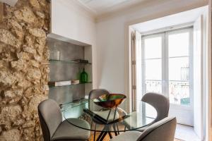 une salle à manger avec une table et des chaises en verre dans l'établissement Living Bairro Alto II, à Lisbonne