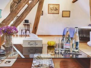 a living room with a glass table with bottles of wine at Le Moulin de Corneil in Mézilles