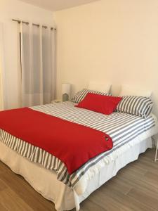 una camera da letto con un letto con una coperta rossa sopra di Apartamento Vilamoura Marina a Vilamoura