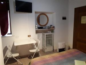 a bedroom with a bed and a desk and a mirror at Comfort Murano room in Murano
