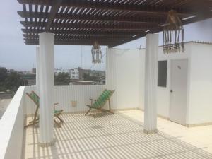 a patio with two chairs on a roof at Antares Paracas in Paracas