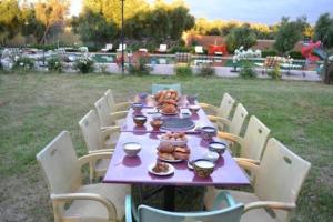 una mesa púrpura con comida y sillas en Atlas Resorts, en Aït Ourir