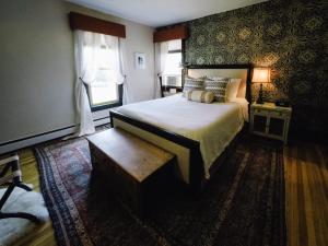 BurdettにあるBurdett House Bed & Breakfastのベッドとベンチのある寝室