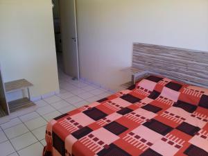 een slaapkamer met een bed met een quilt bij Pousada Flats Recanto Sonhos do Porto in Porto De Galinhas