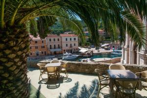 a patio with tables and chairs and a view of a harbor at Villa Mozart in Veli Lošinj
