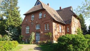 a large brick building with a gambrel roof at Ferienwohnung ehemalige Revierförsterei "Morgensünn" in Kuhstorf