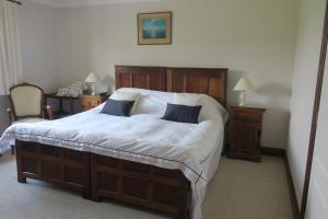 a bedroom with a large bed with white sheets at Highfield in Hay-on-Wye